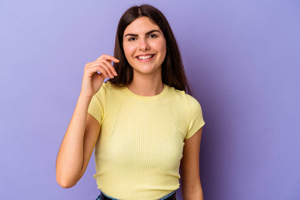 Young caucasian woman isolated on purple background laughing about something, covering mouth with hands. - Photo, Image