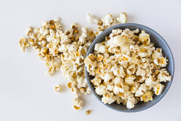A top view of salty popcorn in a bowl on a white background - Fotoğraf, Görsel