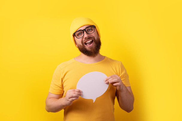 білий чоловік тримає мовну бульбашку з порожнім простором для тексту на жовтому тлі
 - Фото, зображення