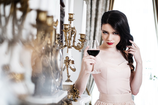 Woman with glass of red wine near fireplace - Foto, Imagem