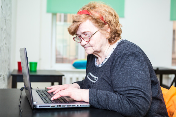 Elder woman typing - Φωτογραφία, εικόνα