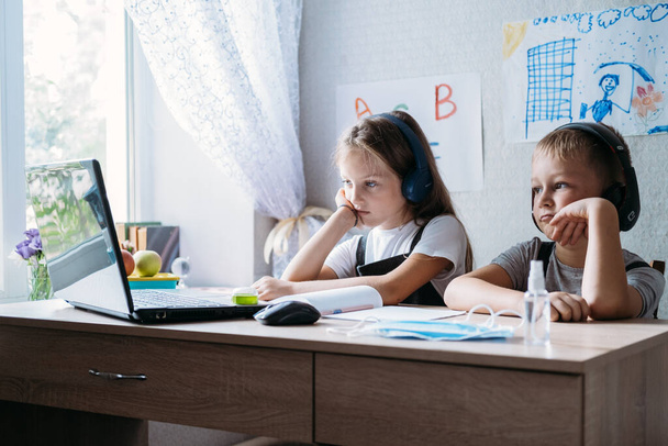 Школьники мальчик и девочка, использующие ноутбук для онлайн-обучения во время домашнего обучения дома. Домашнее обучение, онлайн-исследования, домашний карантин онлайн обучение коронный вирус или онлайн-технологии - Фото, изображение