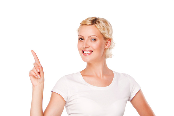 smiling woman with blank white t-shirt pointing up at copy space. isolated - Фото, зображення