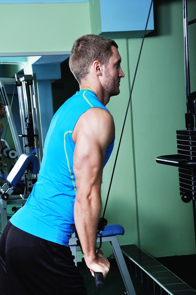 Muscular man exercising in a gym - Фото, зображення
