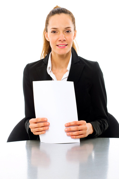 Young businesswoman at a desk with papers in hand - Foto, afbeelding