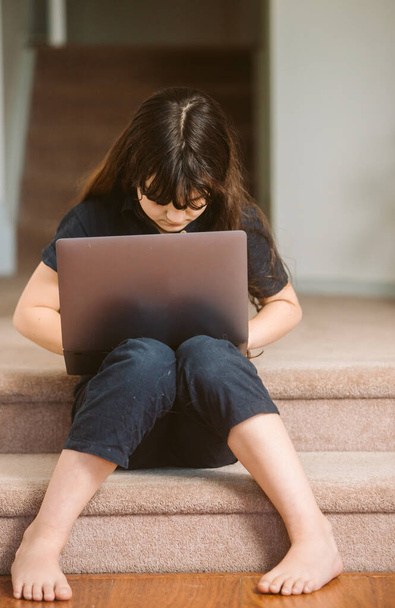 πορτρέτο του χαριτωμένο κορίτσι παιδί κάνει on-line μάθηση χρησιμοποιώντας φορητό υπολογιστή, κατ 'οίκον εκπαίδευση, μακρινή μάθηση - Φωτογραφία, εικόνα