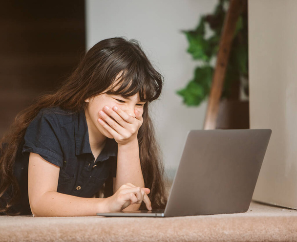 portrait d'une enfant mignonne faisant de l'apprentissage en ligne à l'aide d'un ordinateur portable, de l'enseignement à domicile, de l'apprentissage à distance - Photo, image