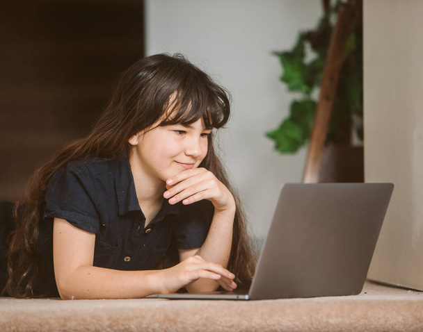 portrait of cute child girl doing on-line learning using laptop, home schooling, distant learning - Photo, Image