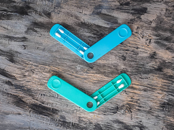 Deux ensembles de bâtons de silicone pour nettoyer les oreilles et le maquillage sur un fond gris, turquoise et bleu - Photo, image