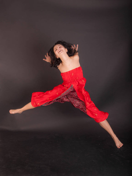 студійний портрет веселої дівчини в червоних штанях
 - Фото, зображення