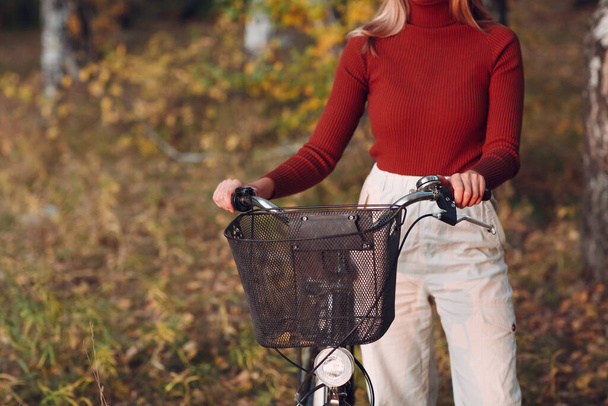 Happy active young woman riding bicycle in autumn park - Fotografie, Obrázek