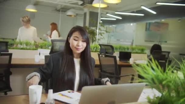 Una donna attraente sta lavorando duro con i suoi colleghi - Filmati, video