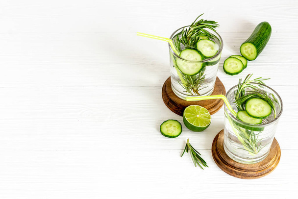 Cold soda drink with pieces of cucumber lime and herbs - Photo, image