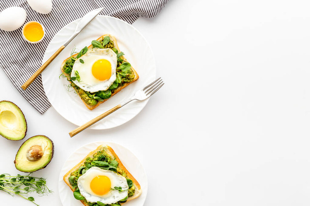 Eggs and avocado with spinach on toasted bread. Top view - 写真・画像