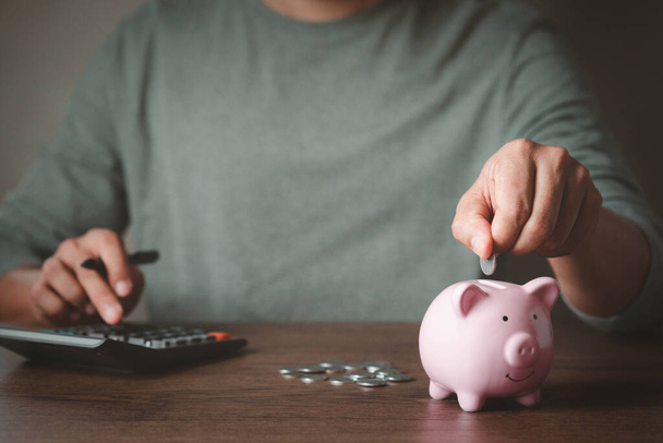 image of man hand putting coins in pink piggy bank for account save money. Planning step up, saving money for future plan, retirement fund. Business investment-finance accounting concept. - Photo, Image