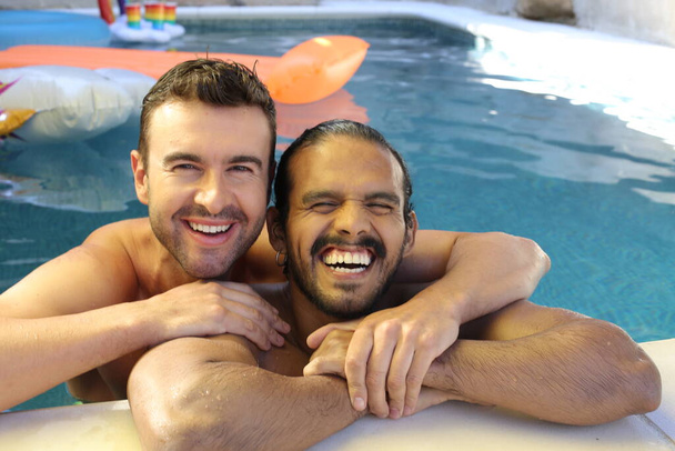 gelukkig jong gay paar genieten van hun tijd samen in zwembad - Foto, afbeelding