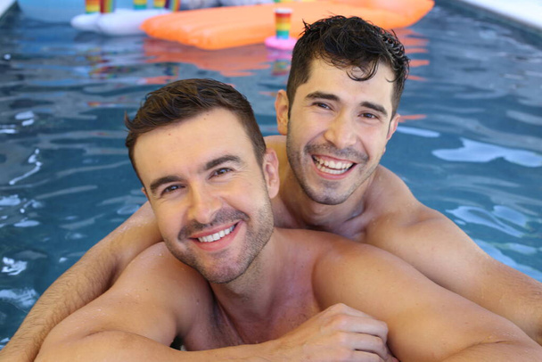 Ευτυχισμένο νεαρό γκέι ζευγάρι που απολαμβάνει το χρόνο του μαζί στην πισίνα - Φωτογραφία, εικόνα