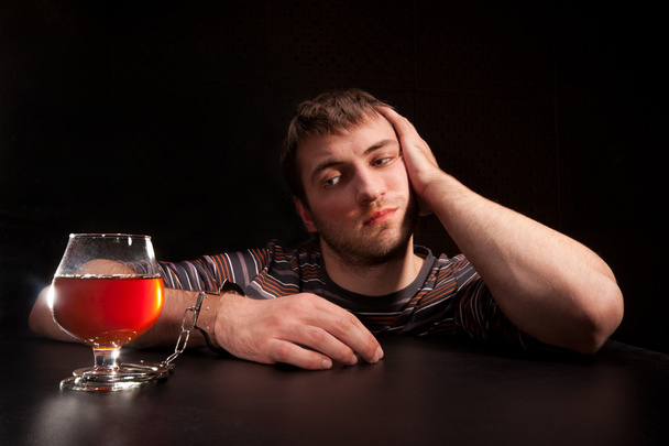 Mies lukittu lasilliseen alkoholia
 - Valokuva, kuva