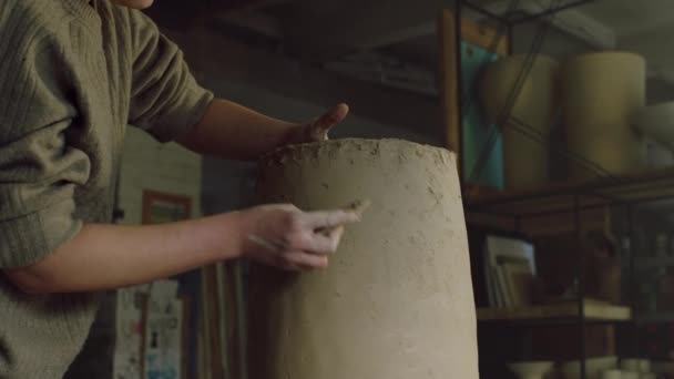 Mujer Potter está raspando jarrón de arcilla cruda - Metraje, vídeo