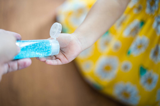 A closeup shot of a girl applying hand sanitizer on her hand - covid concept - Photo, Image