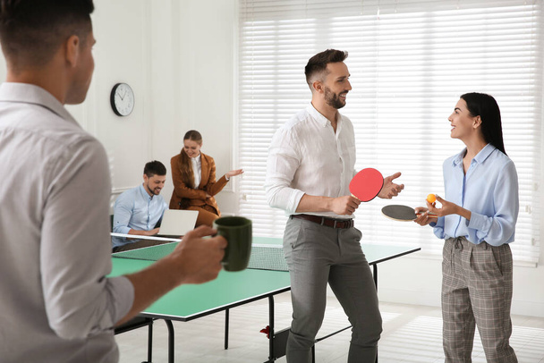 Business people talking near ping pong table in office - 写真・画像