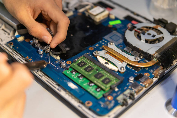 A computer repair technician repairing a laptop - Foto, Bild