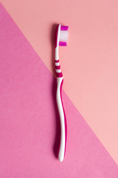 ピンクの背景にピンクの歯ブラシ。スペースのコピー. - 写真・画像