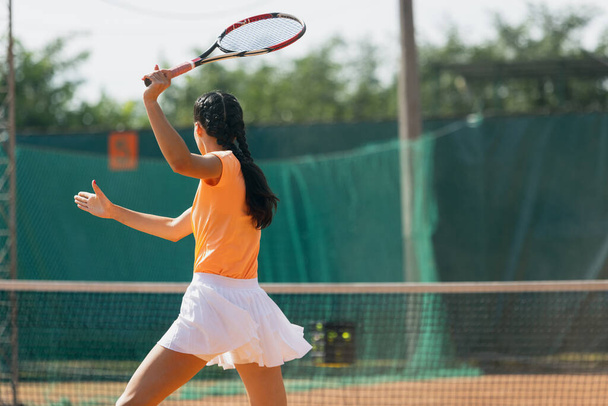 Ενεργός τρόπος ζωής. Νεαρή αθλήτρια που παίζει τένις στο γήπεδο έξω σε φωτεινή καλοκαιρινή μέρα. - Φωτογραφία, εικόνα