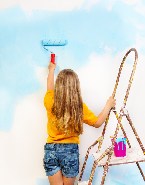 Girl paints the wall - Фото, изображение