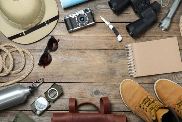 Flat lay composition with different safari accessories on wooden background, space for text - Foto, imagen
