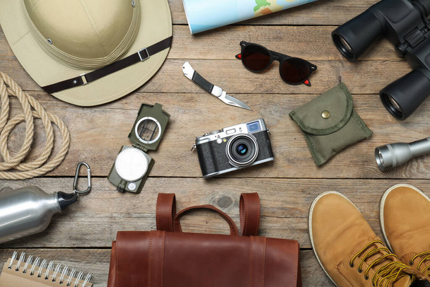 Flat lay composition with different safari accessories on wooden background - Fotó, kép
