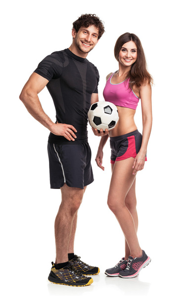 Hombre y mujer atléticos con pelota sobre el fondo blanco
 - Foto, imagen