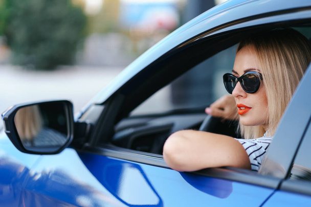 Güneş gözlüklü kadın araba kullanıyor. - Fotoğraf, Görsel