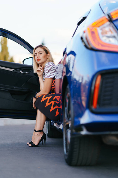 Nainen poseeraa autonsa kanssa - Valokuva, kuva