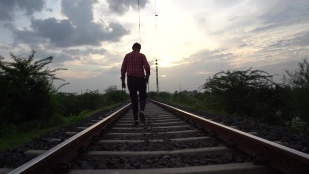 Homme marchant sur la voie ferrée indienne. - Séquence, vidéo