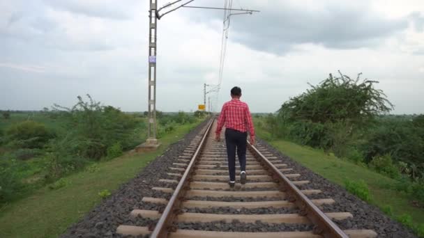 Hombre caminando en la vía ferroviaria india. - Metraje, vídeo