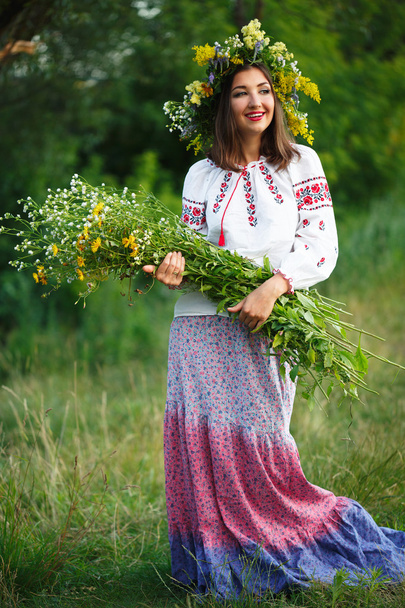 lachende meisje in Oekraïense kostuum met een kroon op zijn hea - Foto, afbeelding
