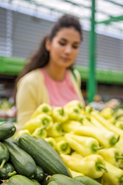 Bella giovane donna che compra verdure sul mercato
 - Foto, immagini