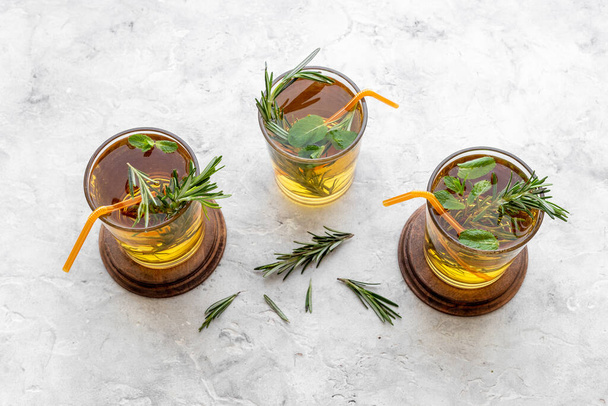 Herbal cold tea beverage with rosemary in glasses - 写真・画像