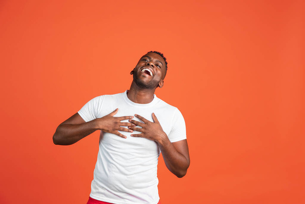 Happy African young man in casual clothes isolated on red color studio background. Concept of human emotions, facial expression, youth, feelings, ad. - Foto, imagen