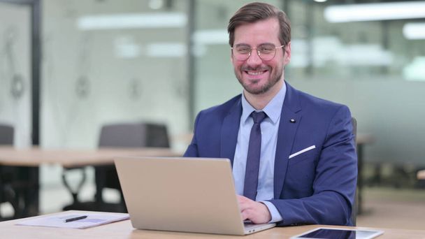 Young Businessman with Laptop Smiling at Camera in Office  - Φωτογραφία, εικόνα
