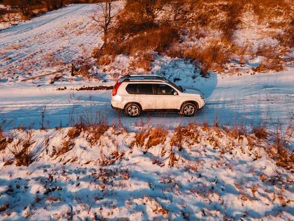 aerial view of suv car on trail road on sunset copy space - 写真・画像