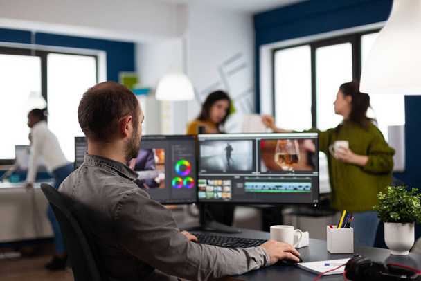 Editor de vídeo corte de imagens trabalhando na montagem de edição de filmes no computador com configuração de monitores duplos - Foto, Imagem