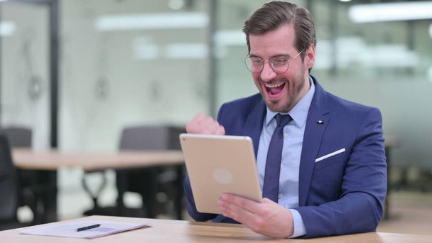 Excited Young Businessman Celebrating Success on Tablet in Office - Photo, Image
