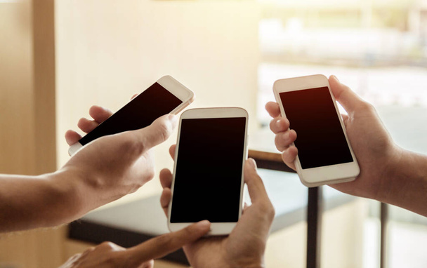 Blisko mężczyzn i kobiet ręce gospodarstwa dotykający telefon komórkowy z pustą przestrzeń do kopiowania wiadomości SMS w kawiarni z jasnym zachodem słońca, Vintage tone.Selektywne skupienie - Zdjęcie, obraz