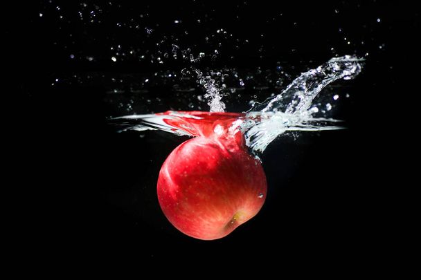 red apple in splashing water refreshing black background - Foto, Imagem