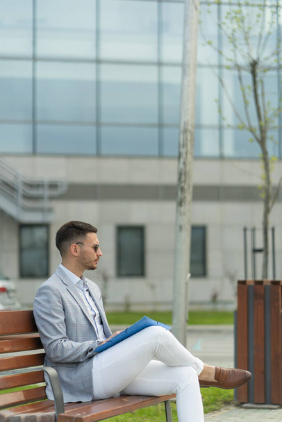 Hombre de negocios guapo está pensando en los planes mientras está sentado en el banco - Foto, Imagen