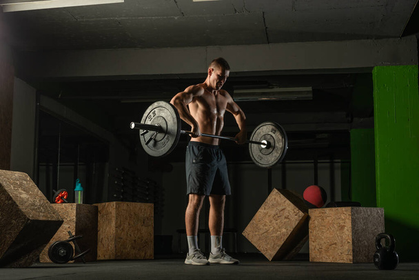 Fit sterke shirtloze atleet doen hurken. Hardcore Cross-fit workout concept. - Foto, afbeelding