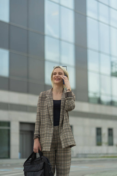 Επιχειρηματίας γελάει στο τηλέφωνο με τους συνεργάτες της, ενώ περπατά - Φωτογραφία, εικόνα