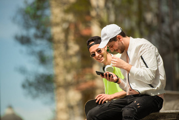 dois amigos do sexo masculino estão olhando para as selfies que tomaram - Foto, Imagem